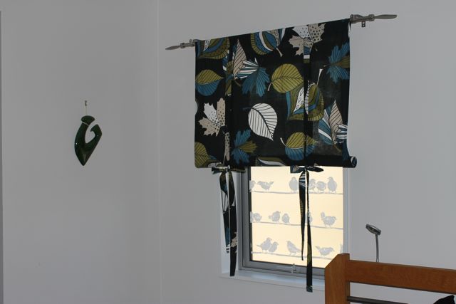 Bedroom window with bird patterned window film, black curtain with leaves