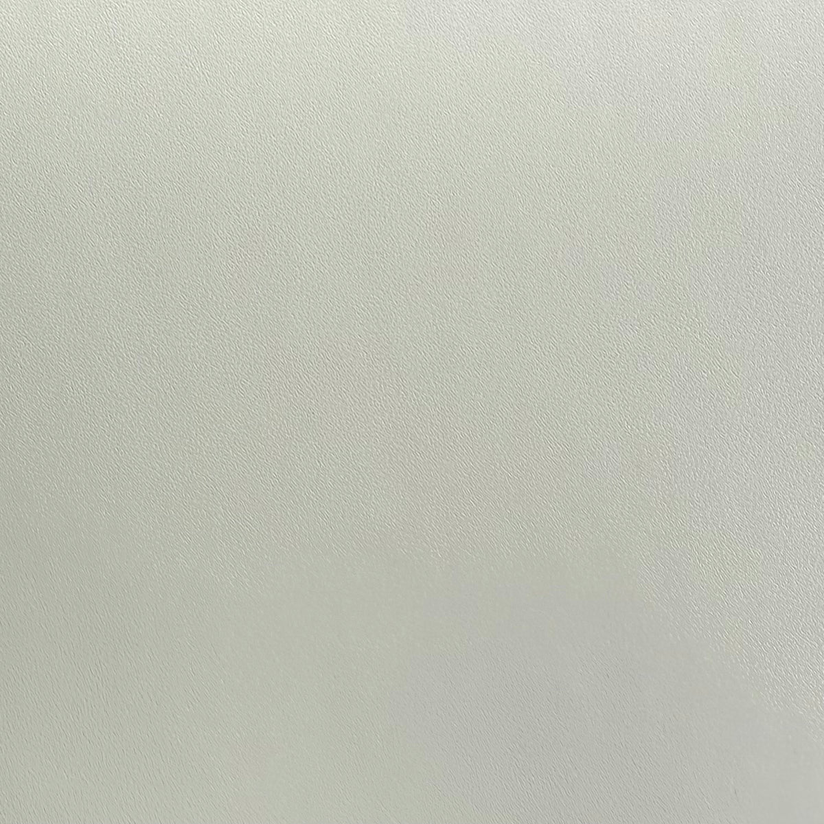 A close-up of an apricot grey textured adhesive vinyl.