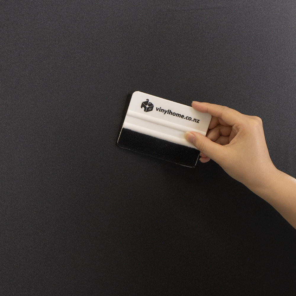 Bedroom with a bed, lamp, and window with blackout window film.