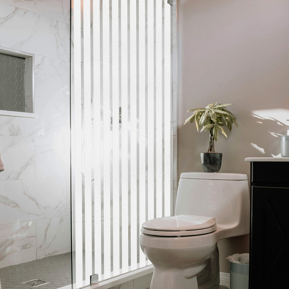 Bathroom with a toilet, plant, and cabinet and shower screen with frosted stripes window film.
