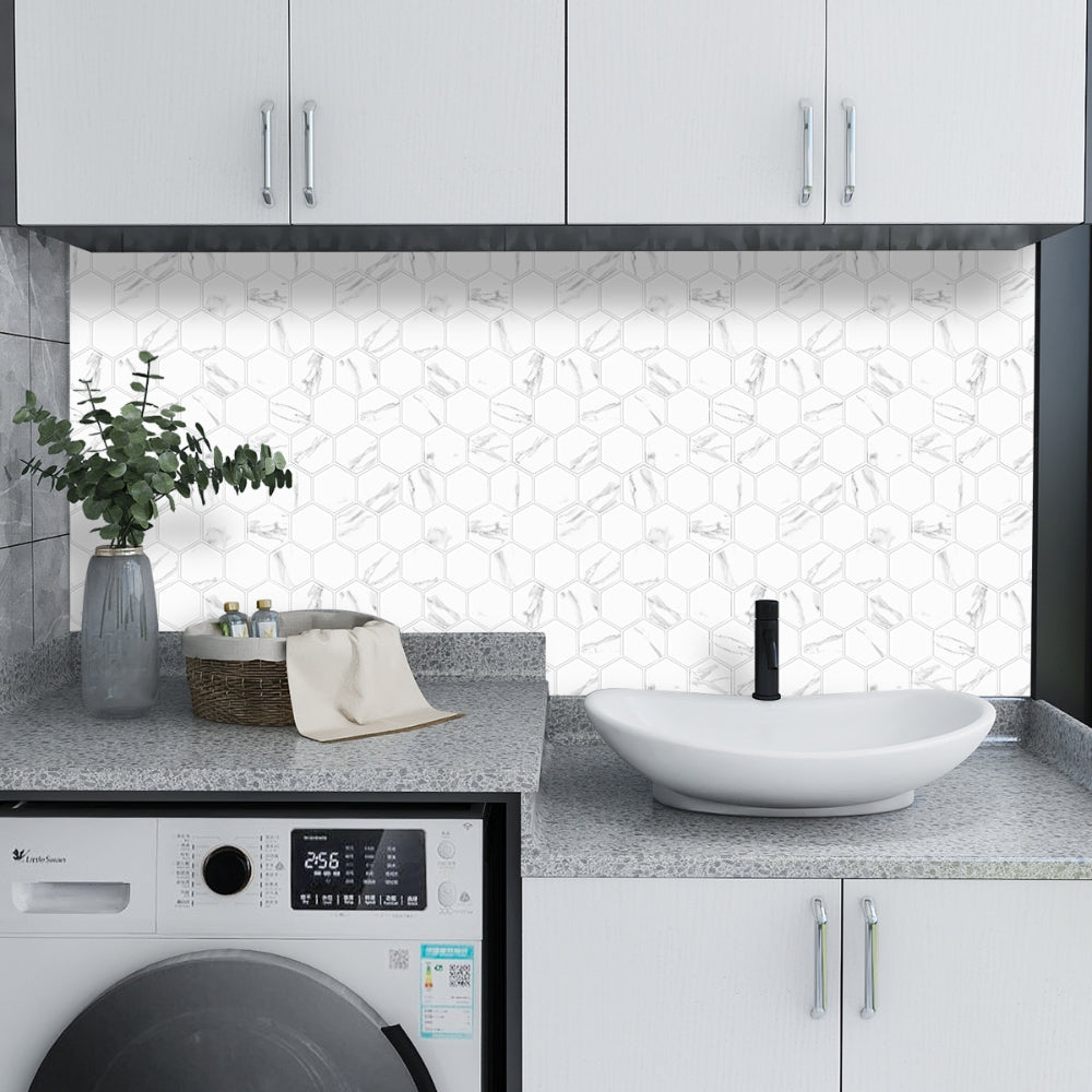 Modern kitchen with white cabinets, marble backsplash, and washing machine.