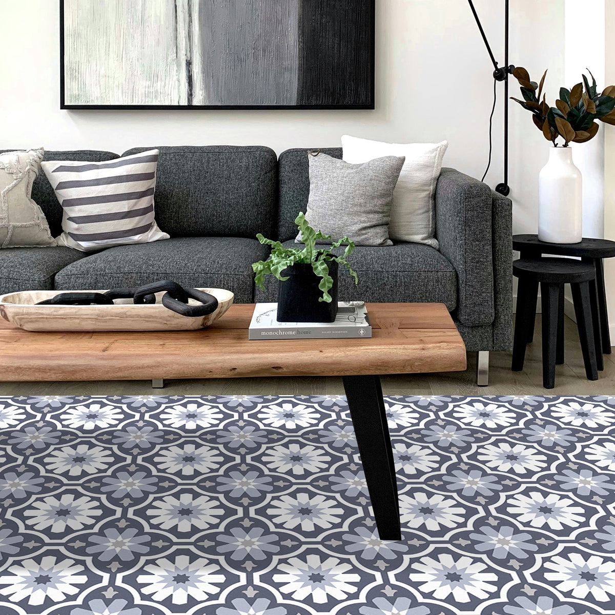 Living room with a gray sofa, wooden coffee table, and flowered floor tiles.