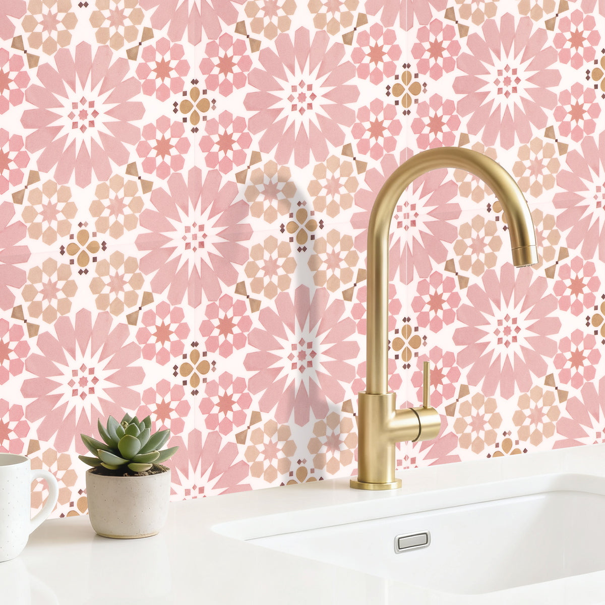 Kitchen sink with gold faucet against a pink floral wallpaper background