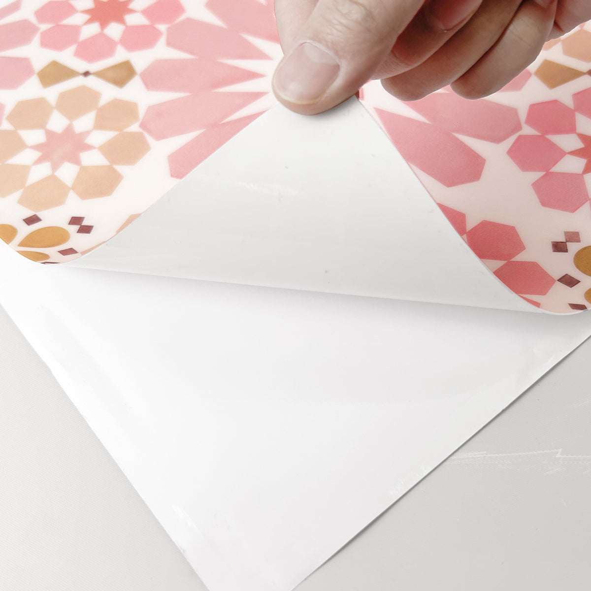 hand peeling a pink floor tile