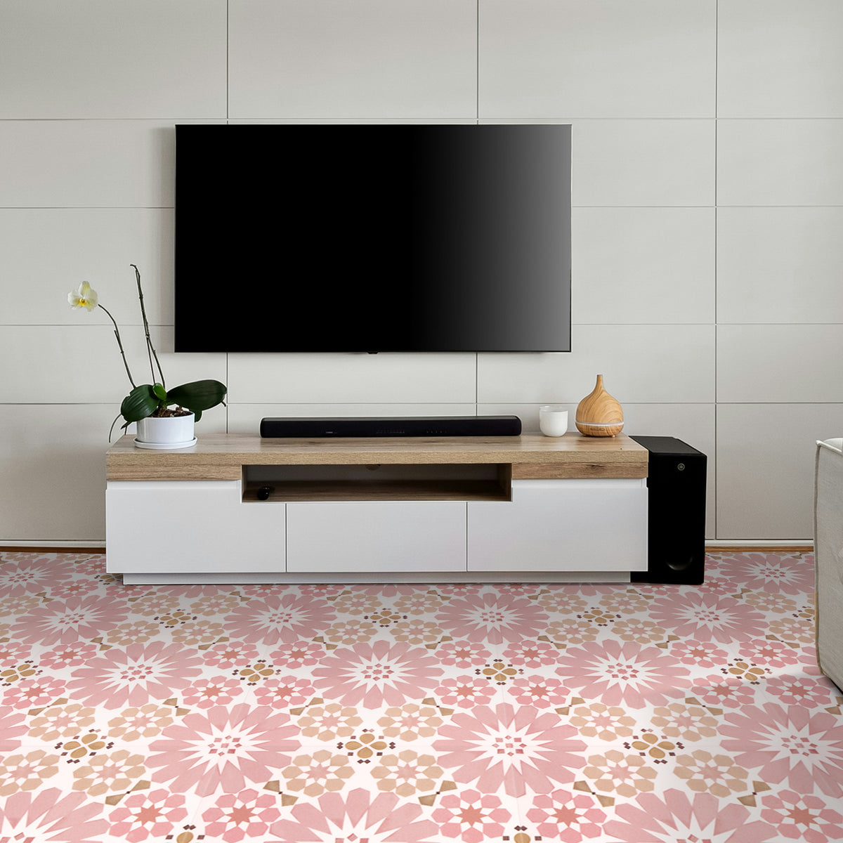 Modern living room with a television mounted on the wall above a wooden entertainment console with flooral pink tiles.