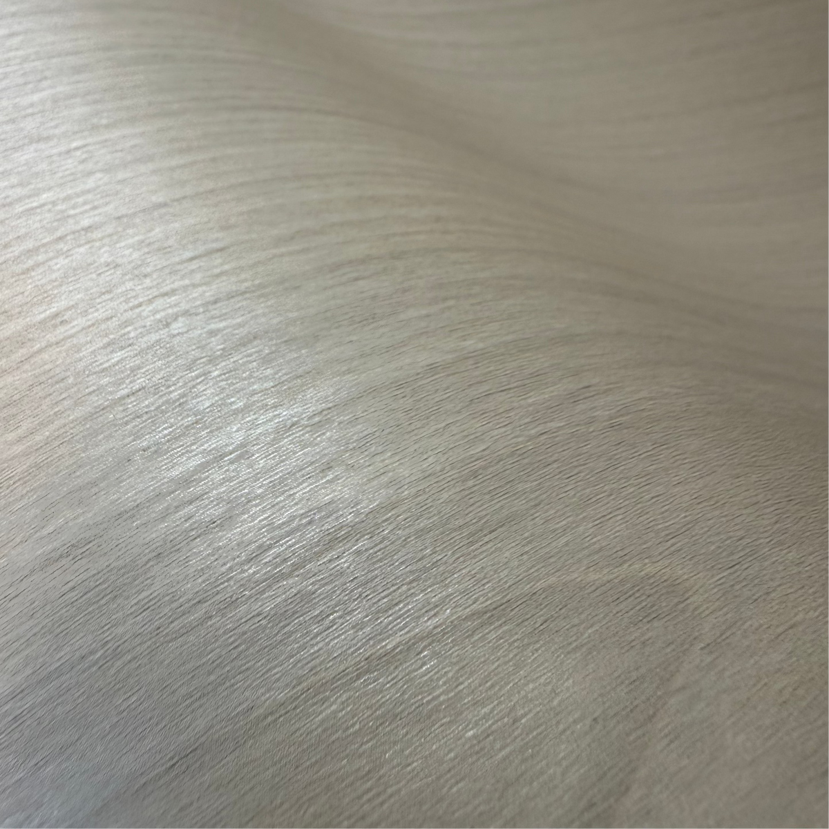 Close-up of light-colored adhesive wood grain vinyl