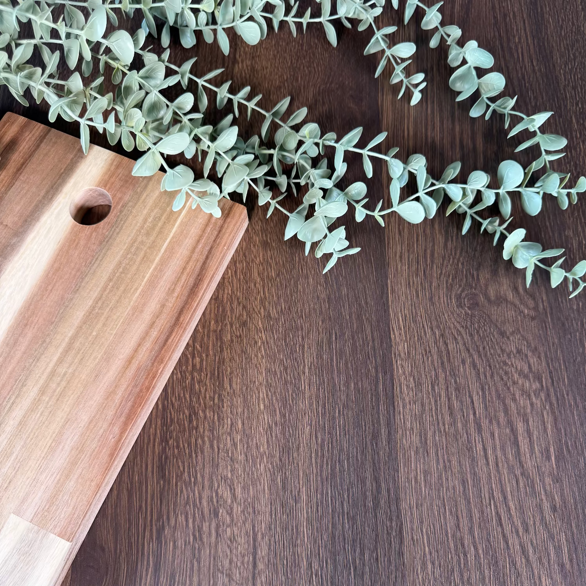 Wooden cutting board with eucalyptus leaves on a oak wood grain adhesive vinyl