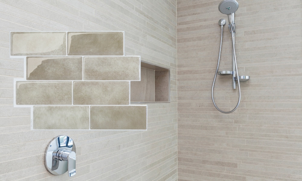 Shower setup with tiled wall, shower head, and control knobs.