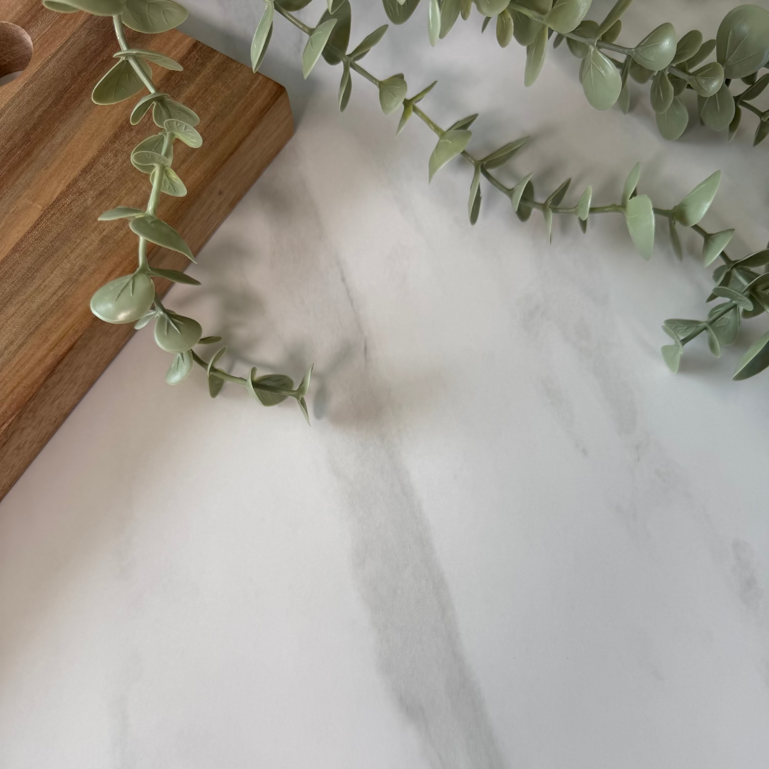 Marble adhesive vinyl covered countertop with a bowl of fruit, books, and a cutting board in a kitchen.