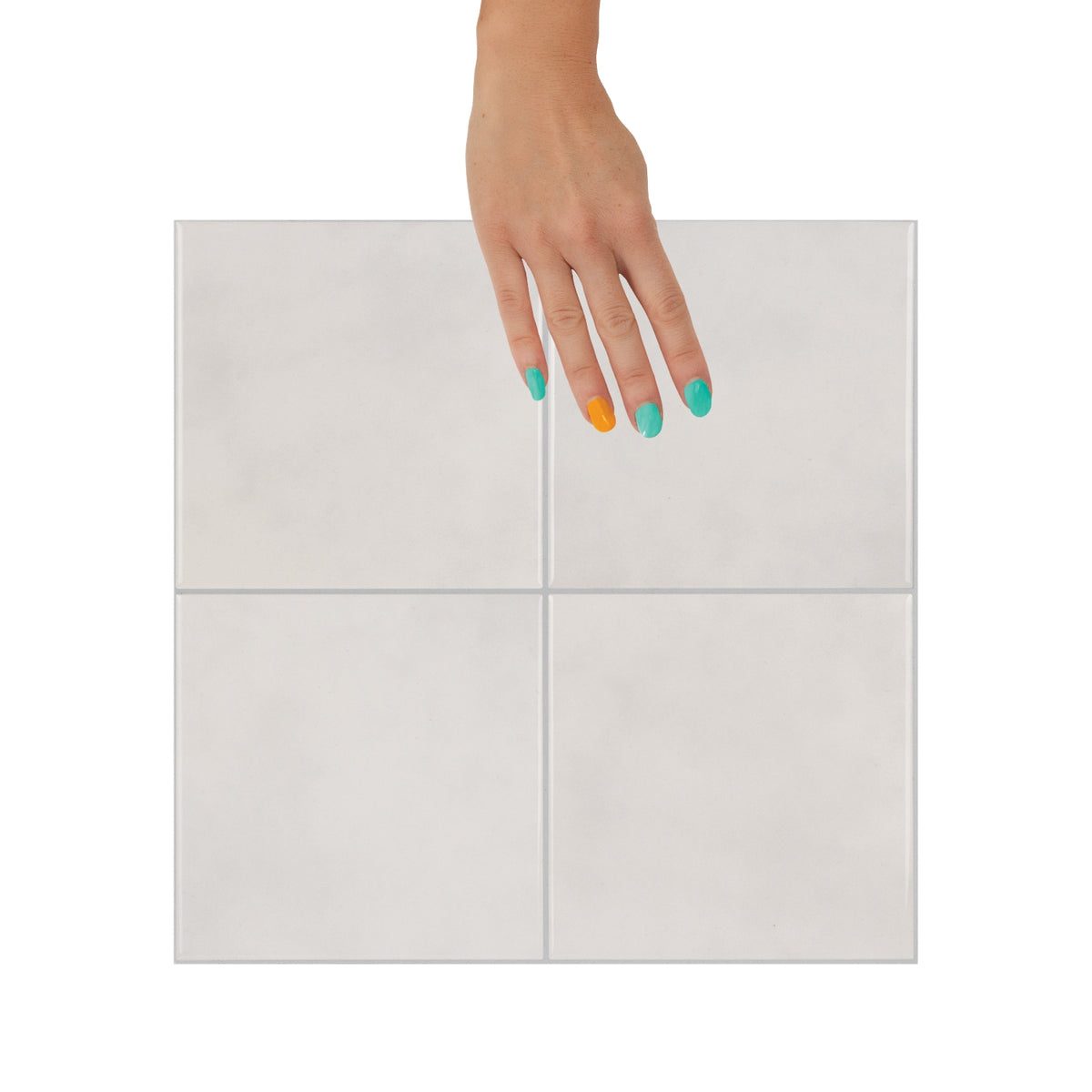 Hand with multicolored nails holding a sandy beige zellige wall tile