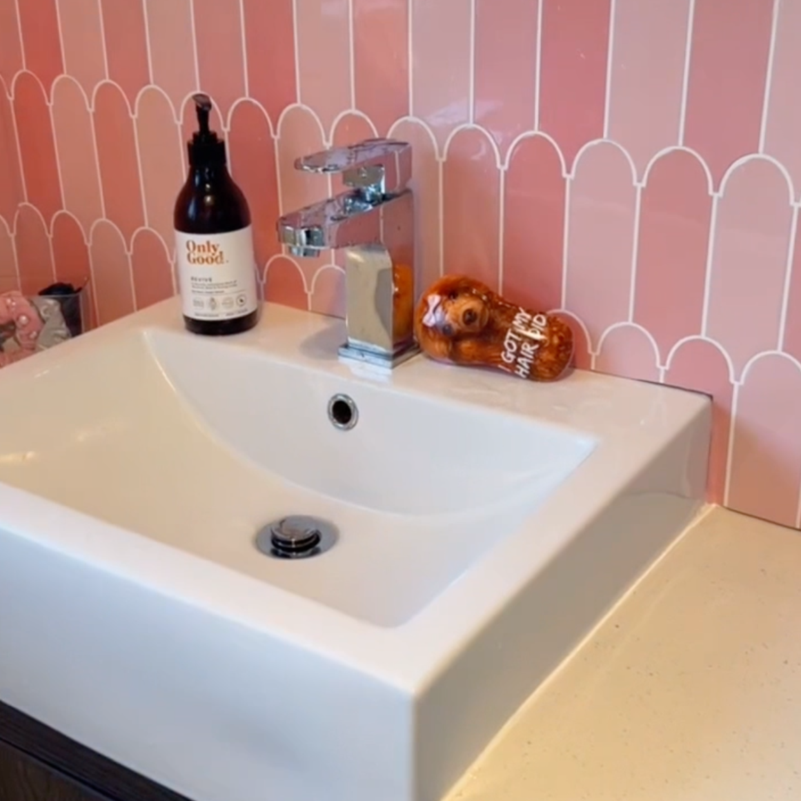 Bathroom sink with pink feather tile backsplash