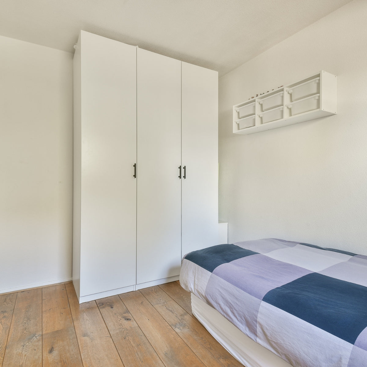 Bedroom with white wardrobe and wooden floor