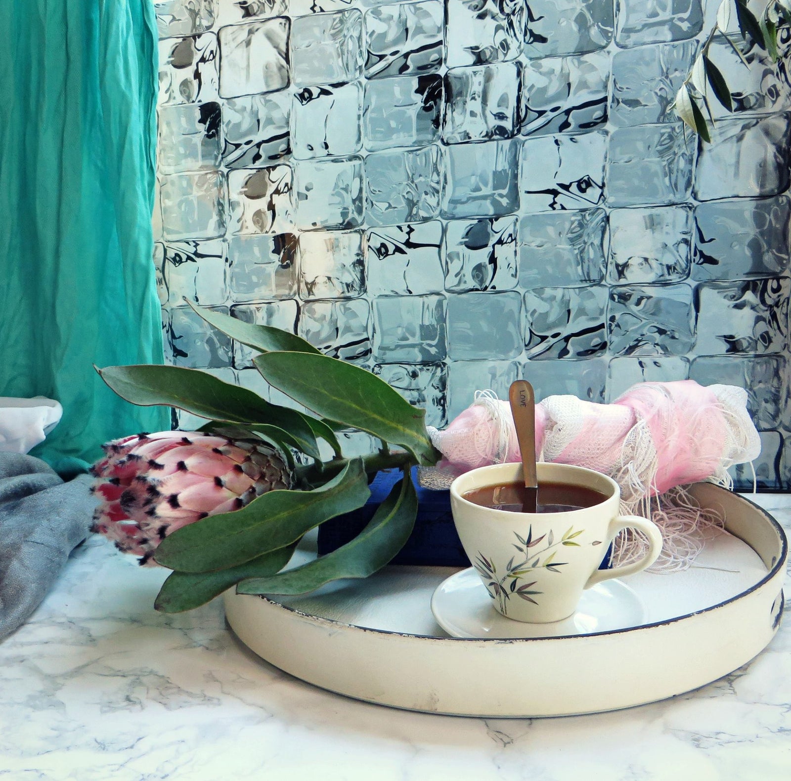 Icecube window film, green curtain to the right and tray with pink flower and tea in front