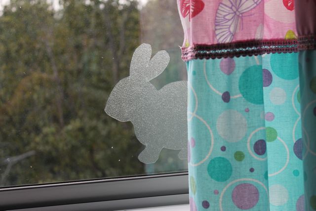 window film bunny decal peeking out behind mint and pink curtain