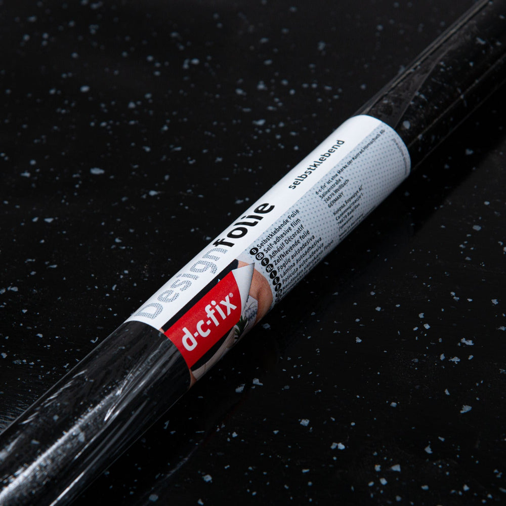 Roll of dc-fix design foil on a dark surface with water droplets