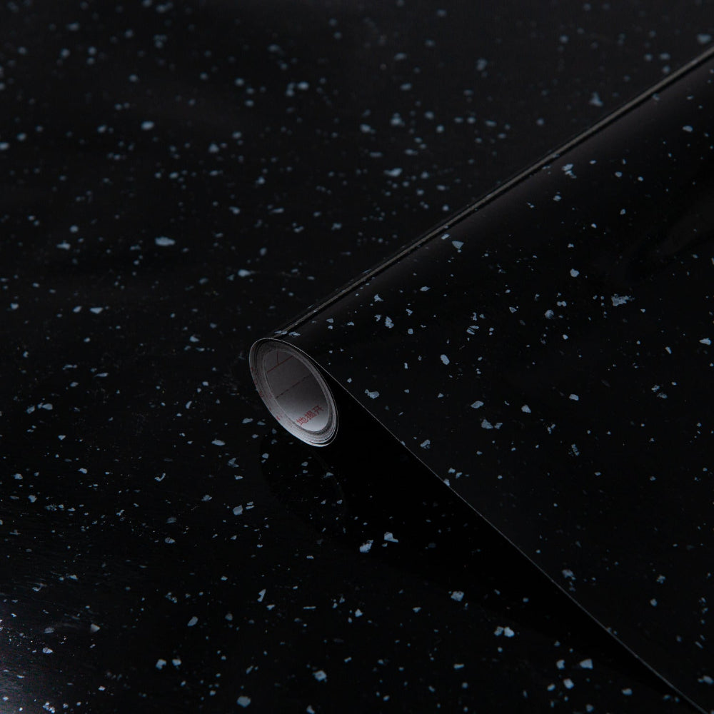 White oval sink on a black speckled countertop with a gray background