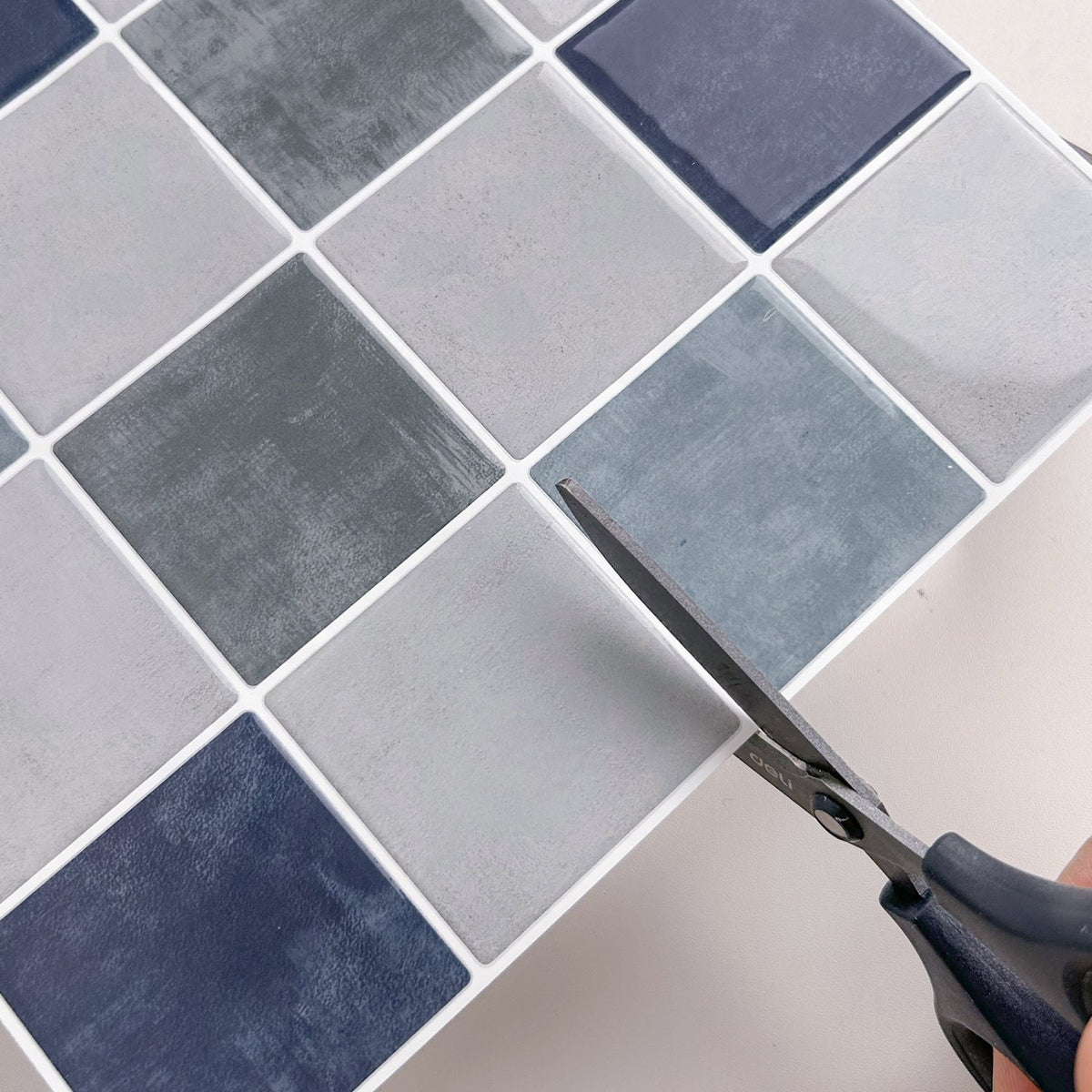 Blue, greige and green checkered tiles with white grout cut