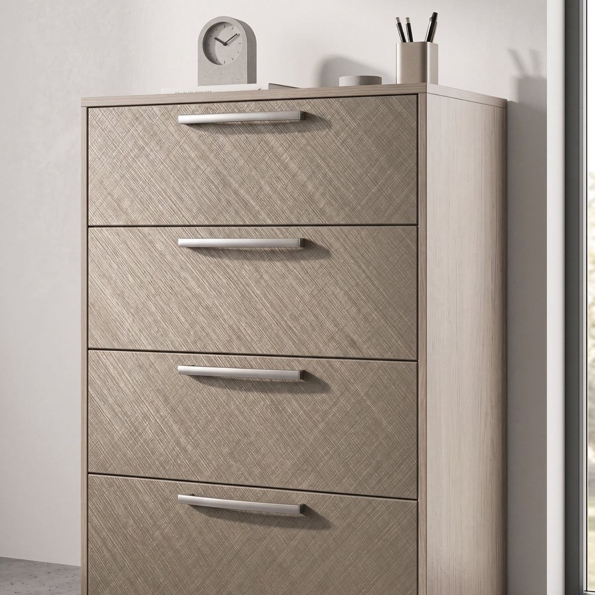 Brushed Linen Brass Metallic adhesive vinyl wrapped dresser with four drawers and decorative items on top against a light background