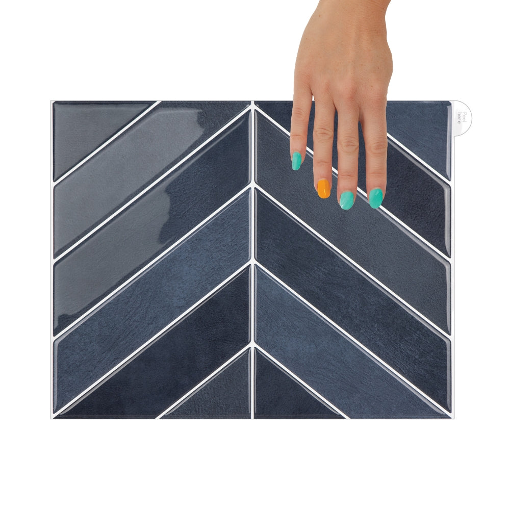 Navy blue chevron patterned tile with a hand holding it