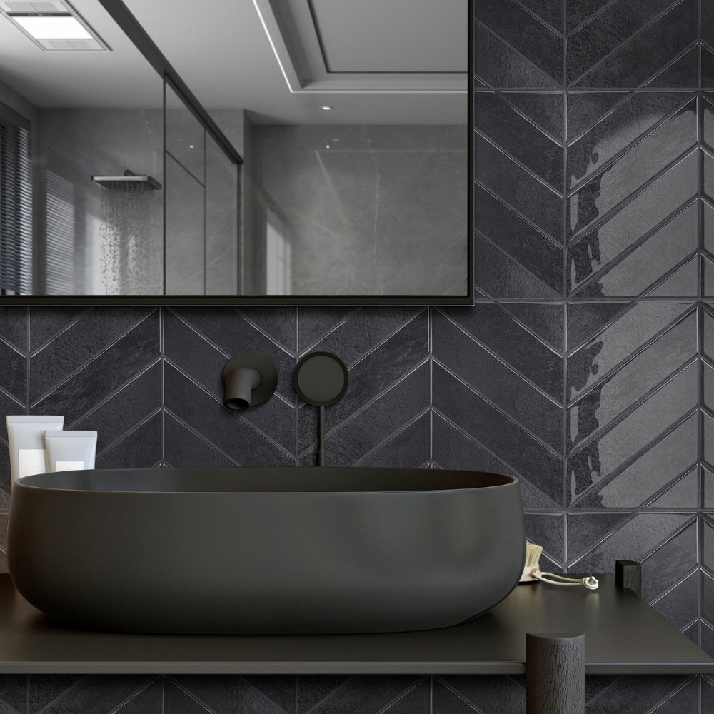 Modern bathroom with a black sink against a chevron-patterned wall.