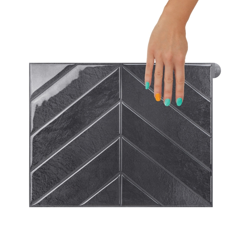 Modern kitchen with black chevron-patterned backsplash and stainless steel fixtures.