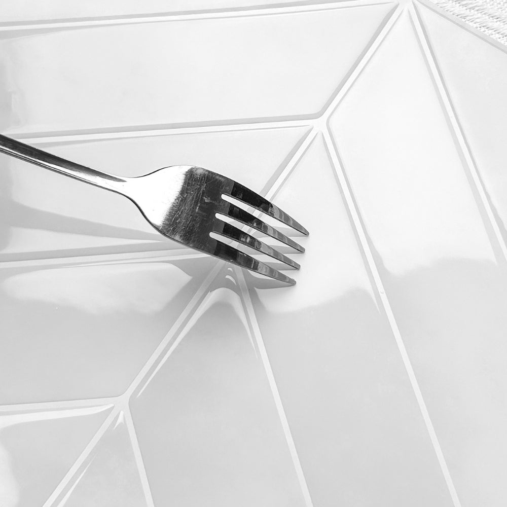 Silver fork on a white chevron tile