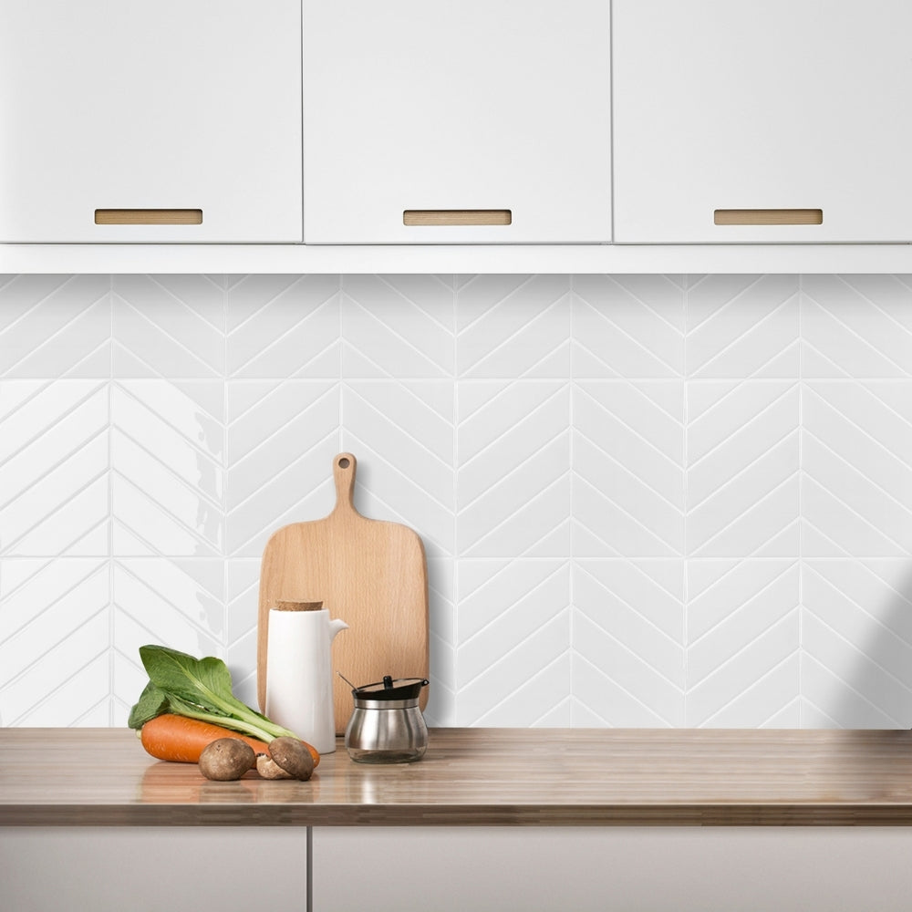 Modern kitchen with wooden countertop, white cabinets, and a chevron patterned backsplash.