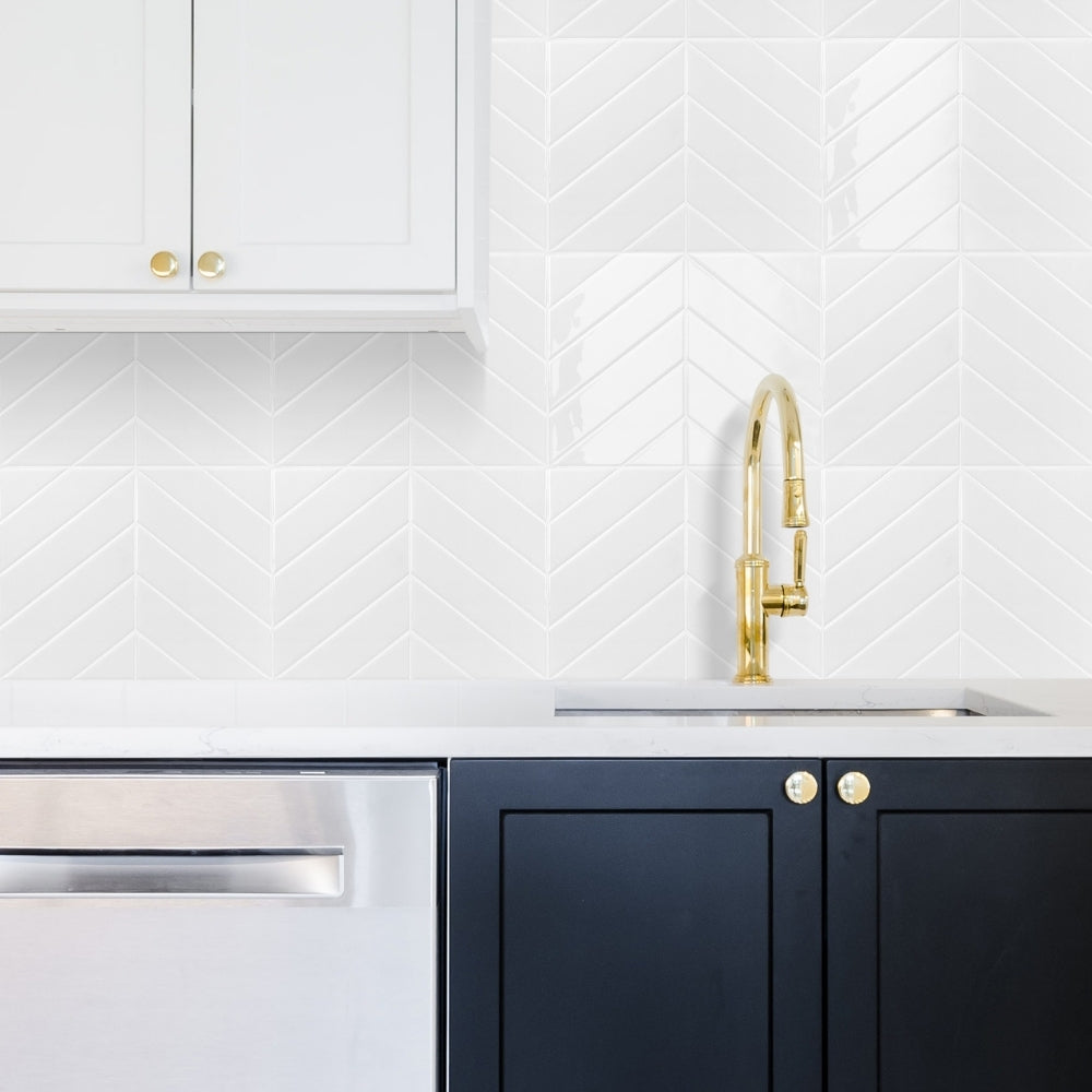 Modern kitchen with white cabinets, gold faucet, and black lower cabinets.