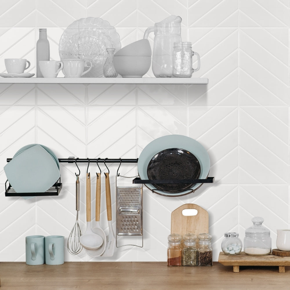 Modern kitchen with white tiled wall, shelves with kitchenware, and hanging utensils.