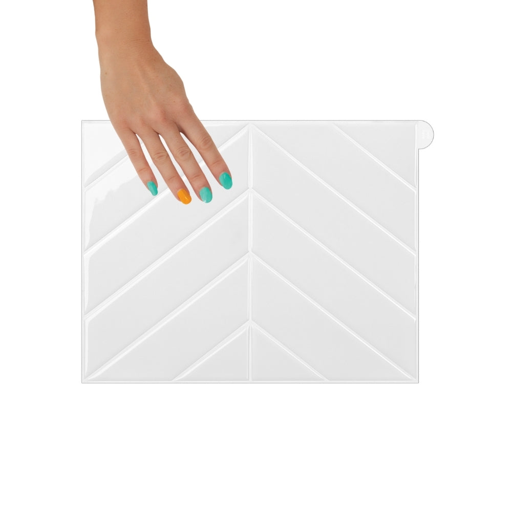 White chevron tile held by a hand on a white background