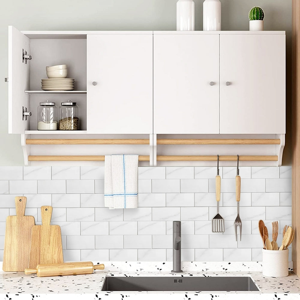 Modern kitchen with white cabinets, wooden shelves, and a marble tiled backsplash.
