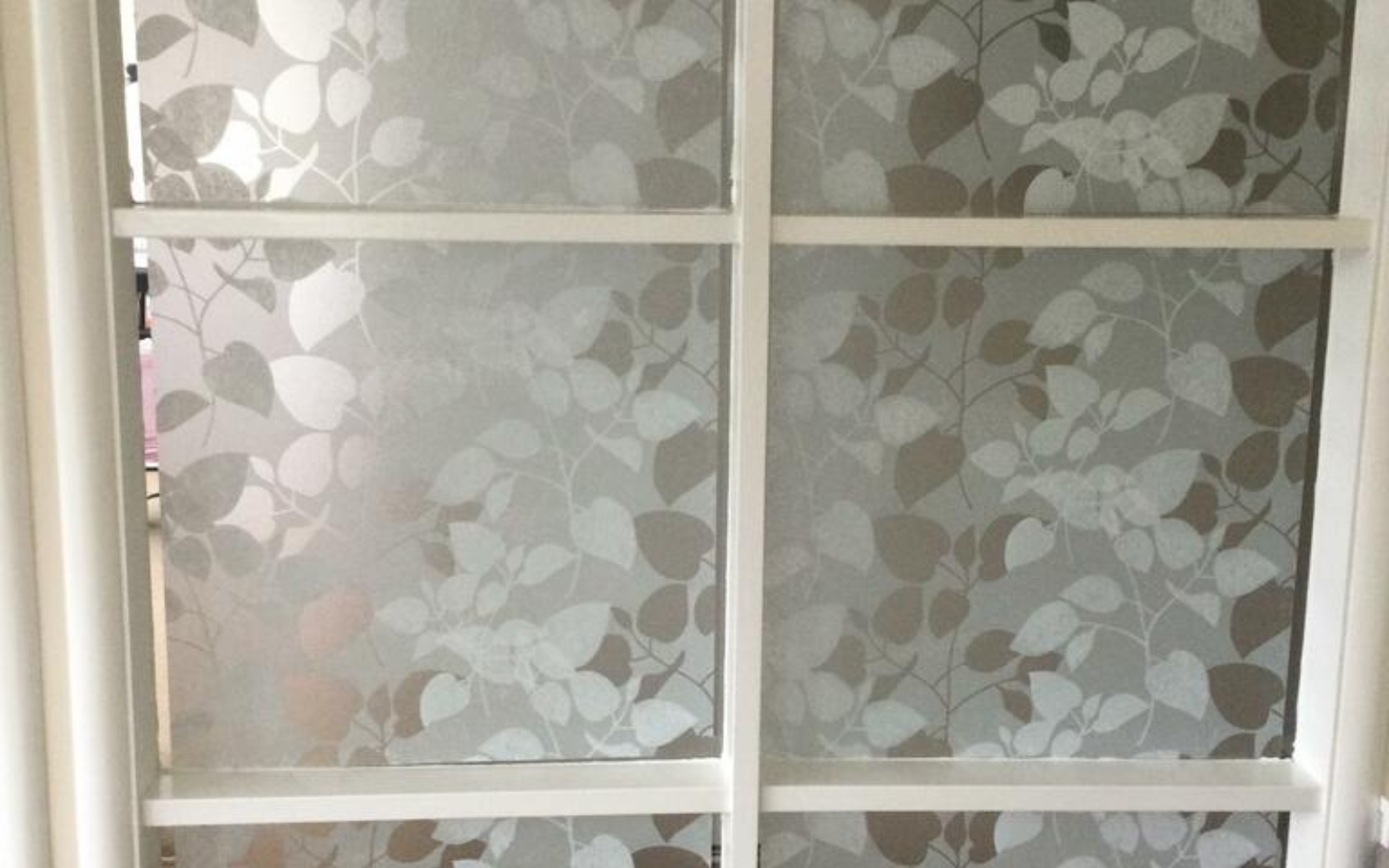 Window with decorative glass panels featuring leaf patterns.