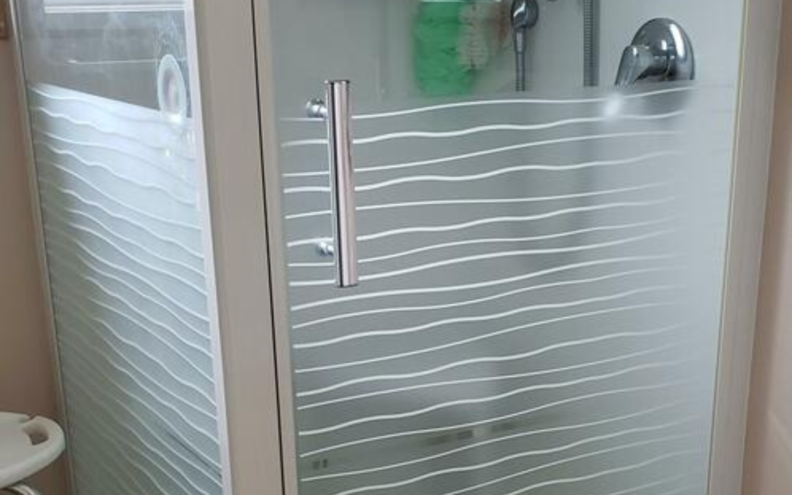 Glass shower enclosure with decorative window film.