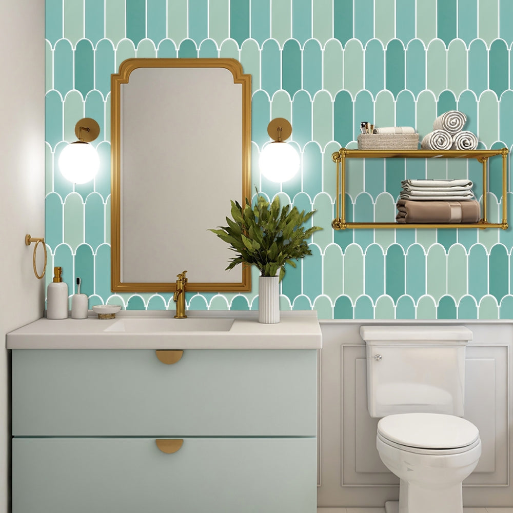 Bathroom with teal geometric tiles, gold mirror, and vanity.
