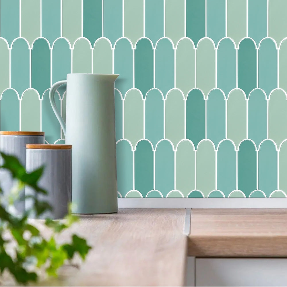 Decorative wall with green geometric pattern and ceramic pitcher on a wooden surface