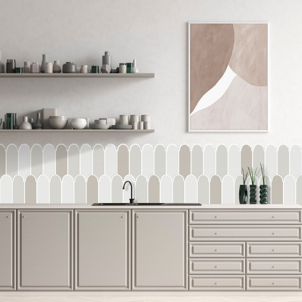 Modern kitchen with light grey cabinets and feather tiles, white shelves, and an abstract art piece on the wall.