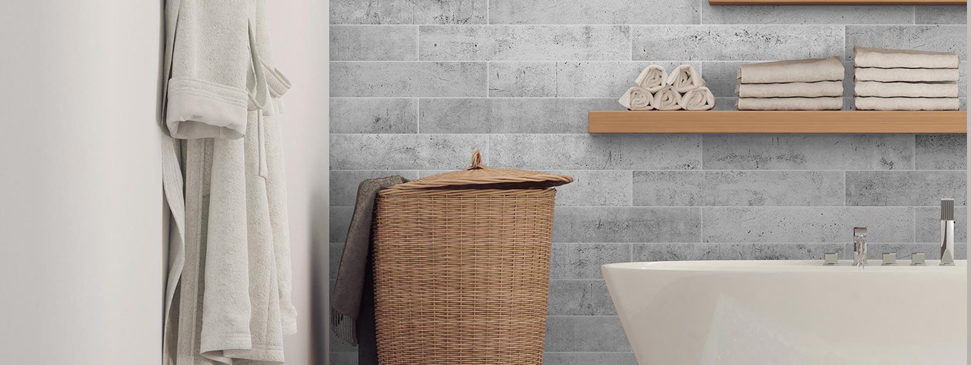 Grey concrete wall tiles behind a white bath and laundry basket, wooden shelfs on wall with white towels
