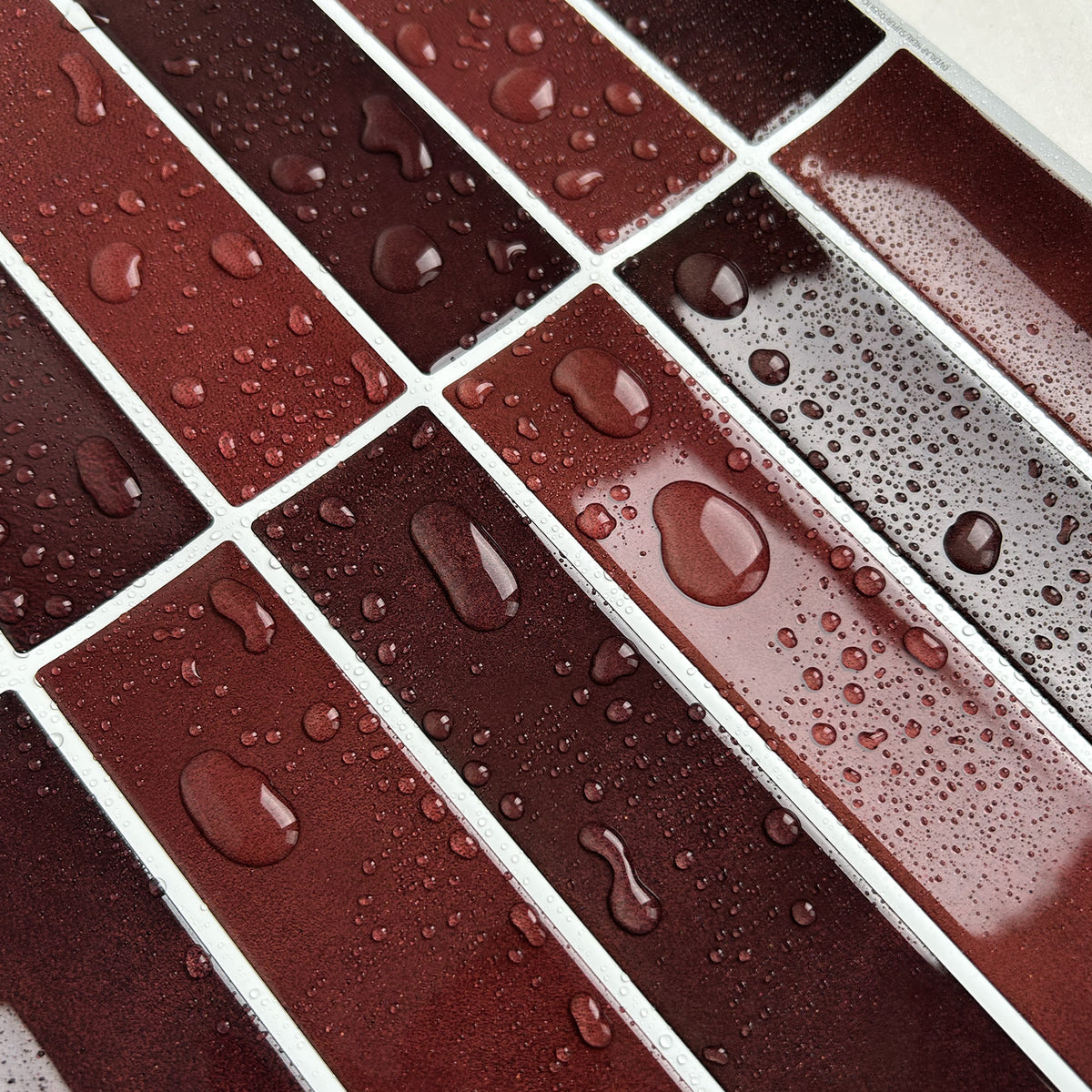 Close-up of water droplets on a grid of red and brown tiles.