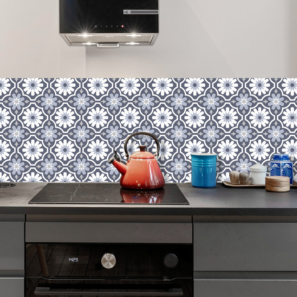 Kitchen with a patterned backsplash, red teapot, and blue container.