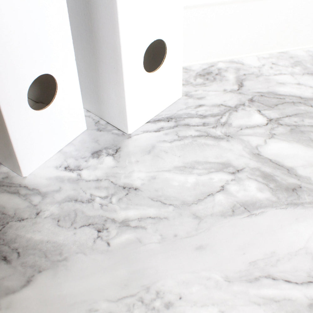 Close-up of a marble-patterned surface with white folders.