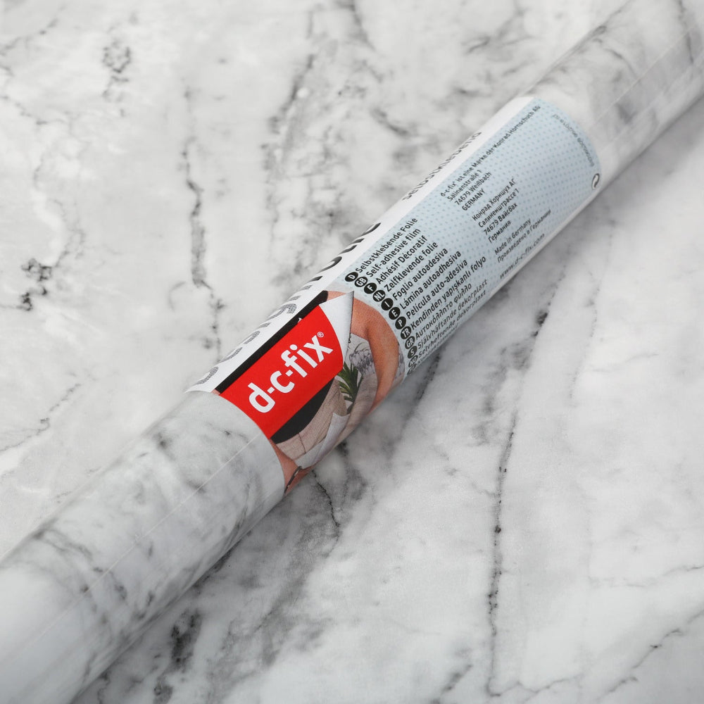 Roll of marble romeo vinyl with &#39;d-c-fix&#39; branding on a marble surface