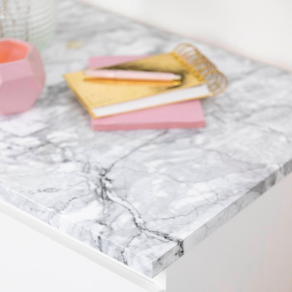 Marble-patterned surface with colorful items on a white background