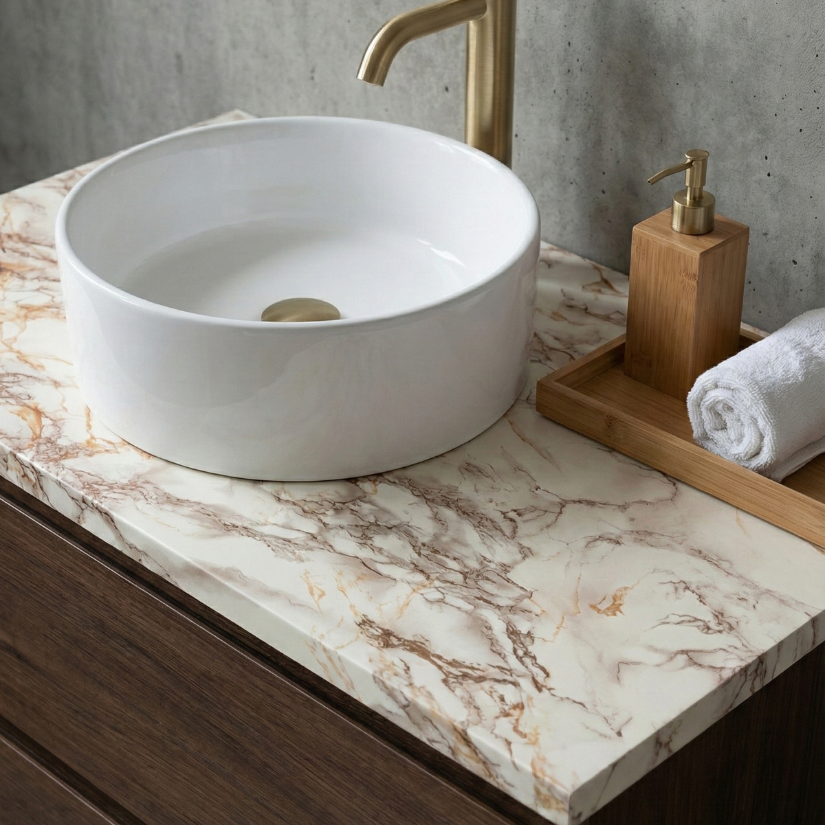Bathroom vanity with white round sink, gold faucet, and marble countertop.