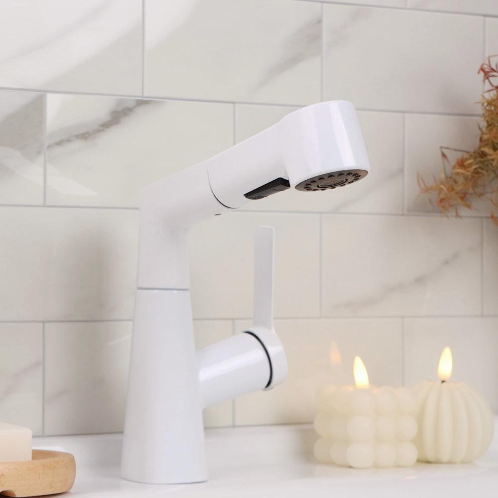 White faucet on a bathroom sink with candles and soap