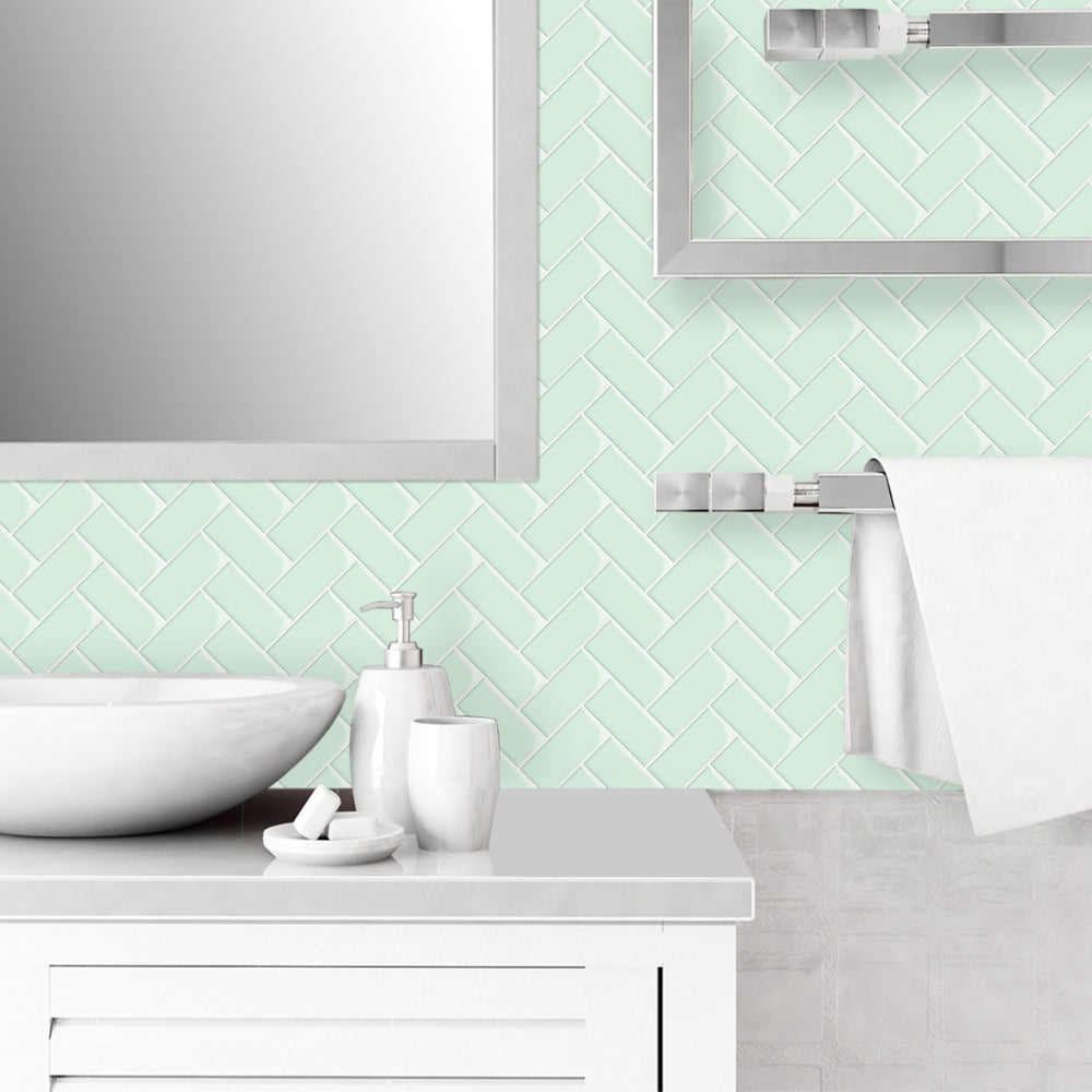Bathroom with mint green tiled wall, white sink, and accessories.