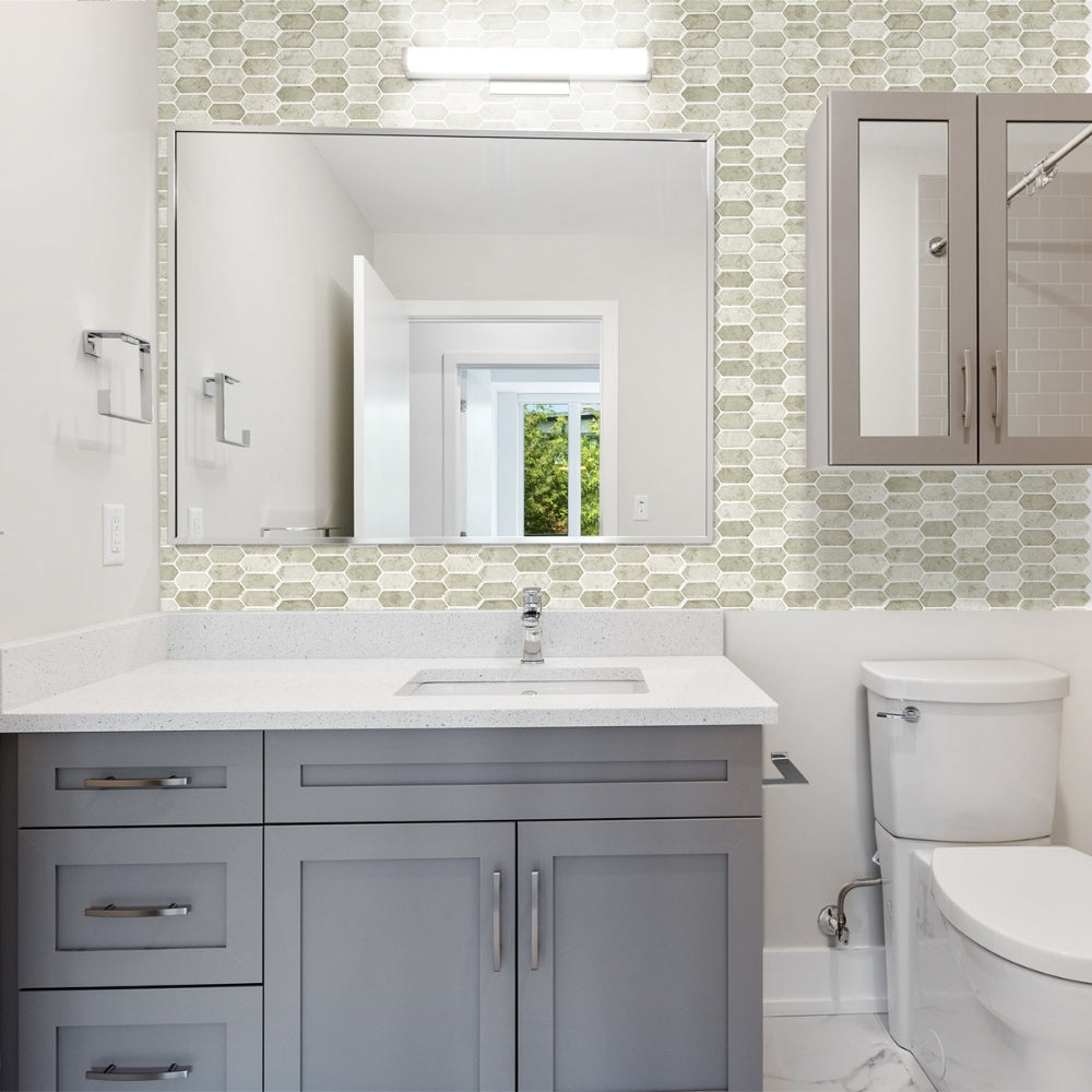 Modern bathroom with gray vanity, white sink, and mosaic tile backsplash.