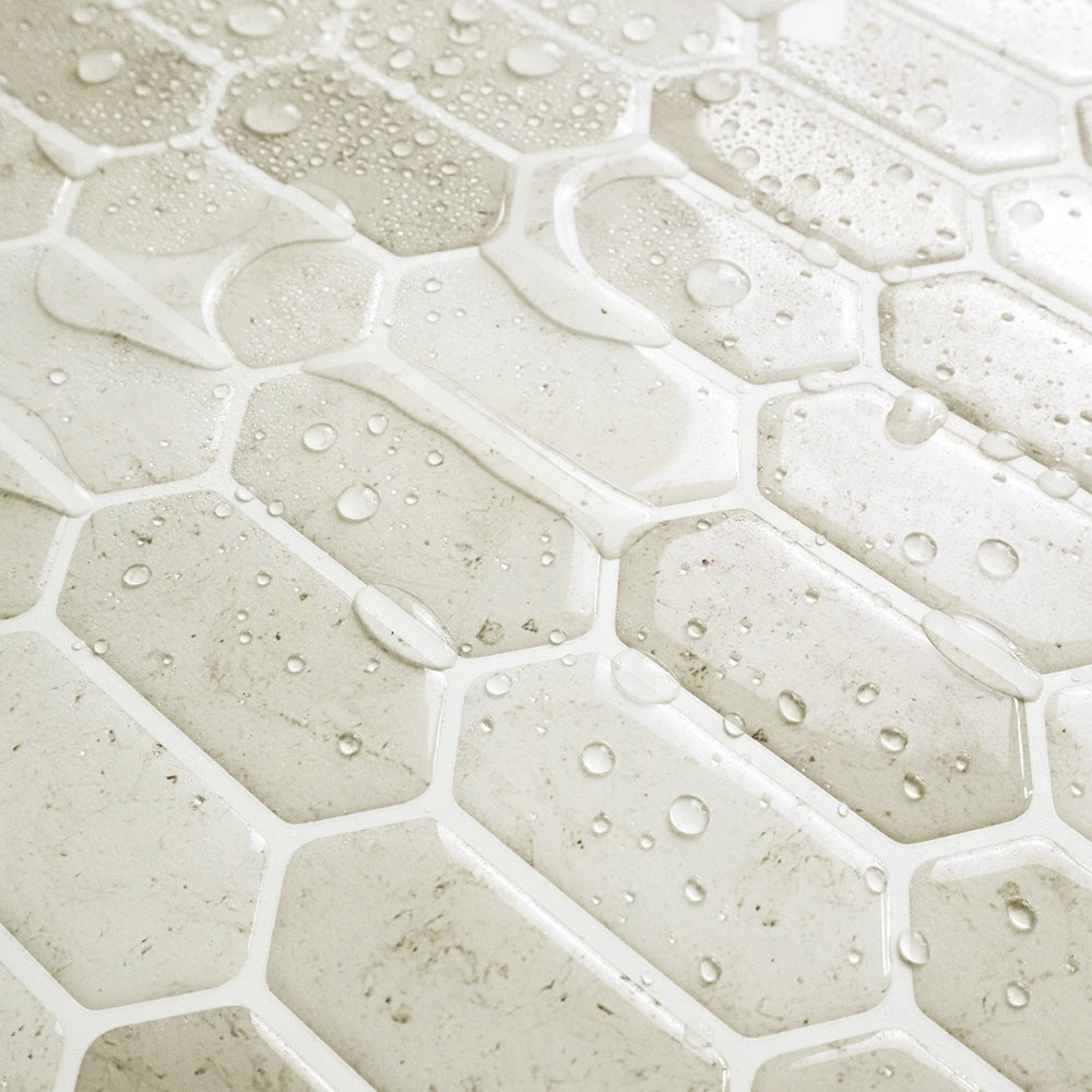 Close-up of hexagonal stone tiles with water droplets on a light background