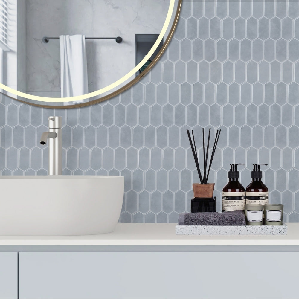 Bathroom with geometric tile pattern, sink, and decorative items.