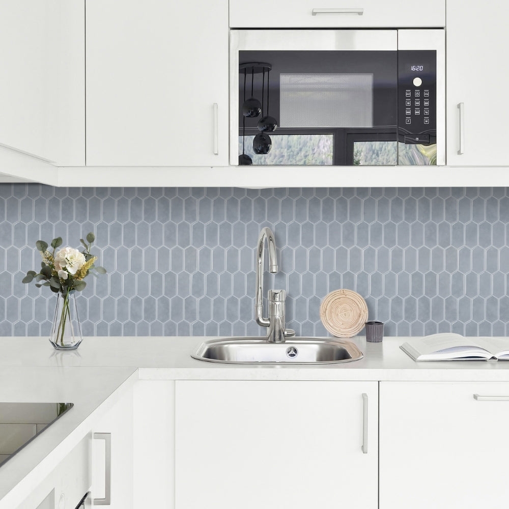 Modern kitchen with white cabinets, blue backsplash, and a sink.