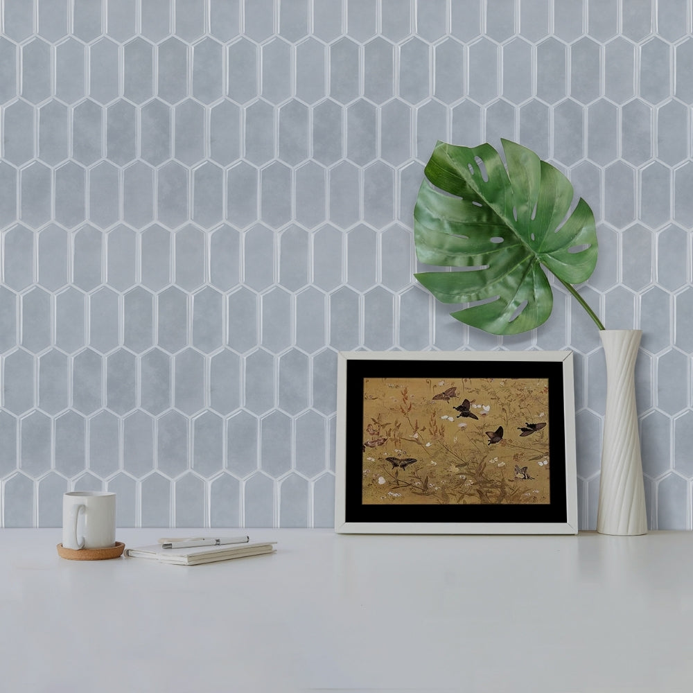 Framed artwork on a table with a geometric-patterned wall in the background
